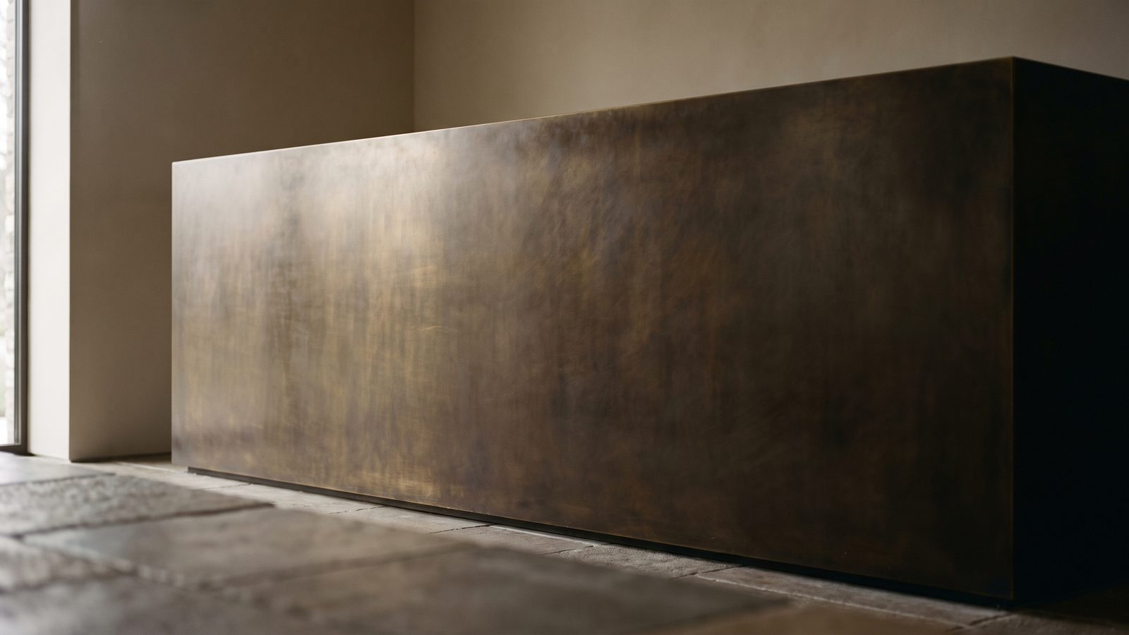 Blackened brass feature panel, warm brown-black flat surface
