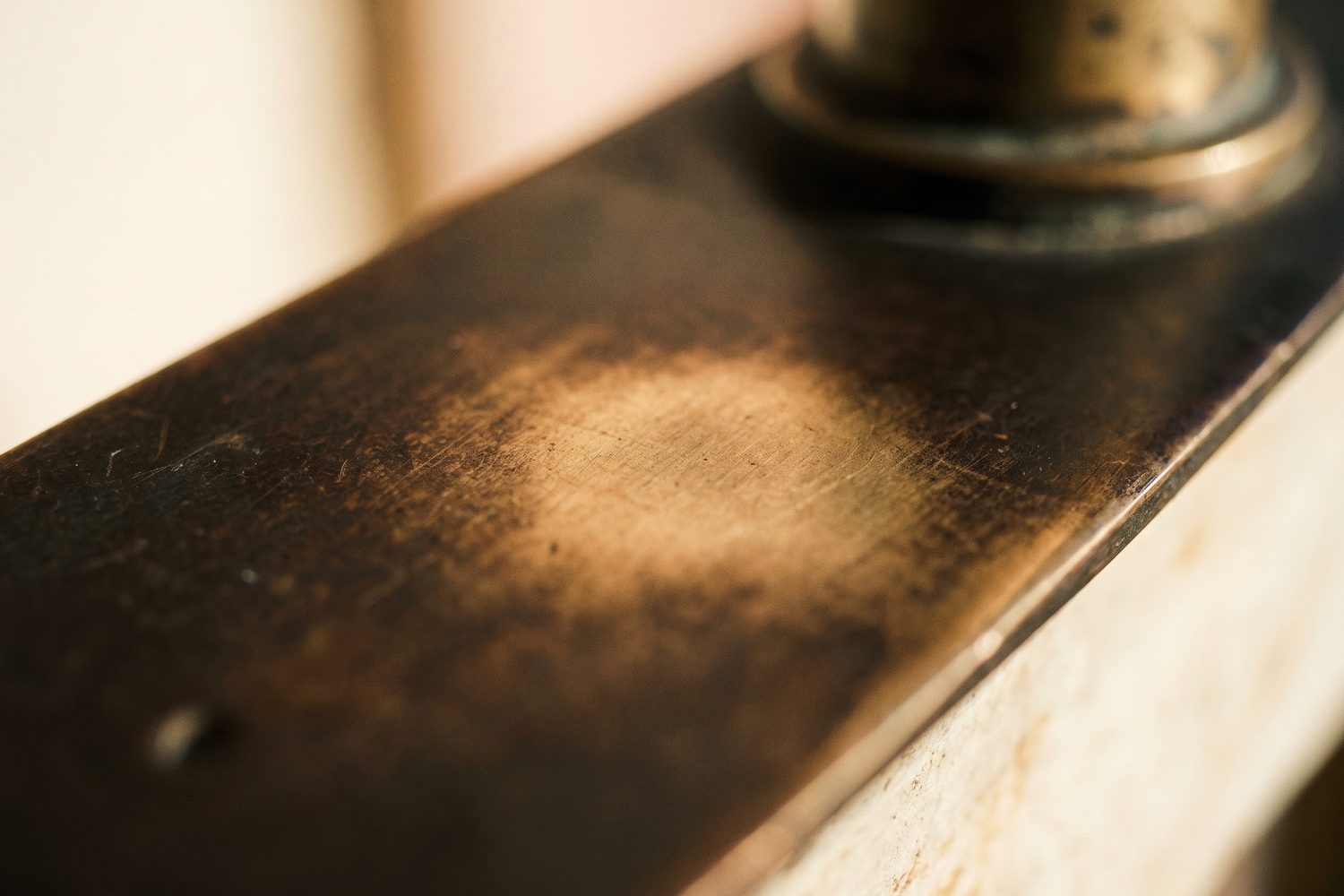Blackened brass worn back to warm brass at a touch point