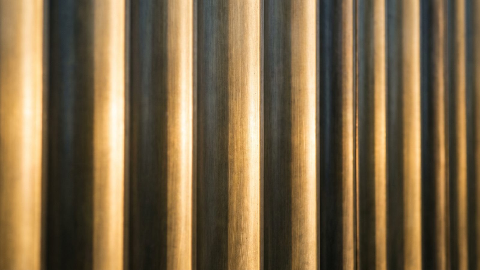 Vertical fluted brass panel wall in low raking light