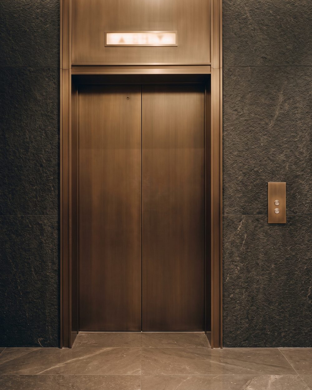 Bronze lift door face as a flat plane