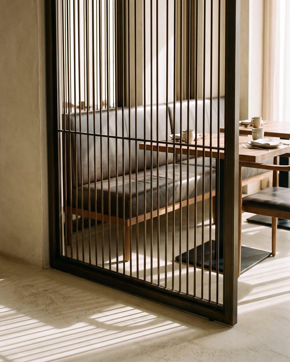 Bronze PVD metal screen dividing a restaurant banquette